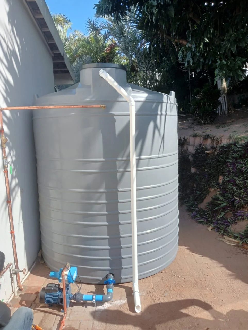 Residential water storage system with multiple tanks and pipes.